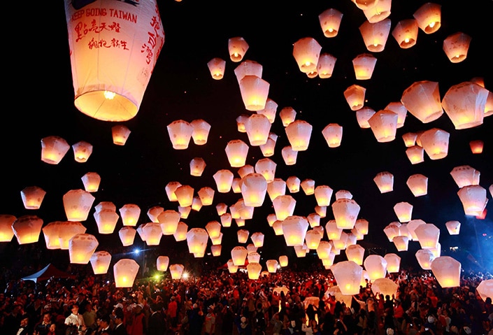 a photo of floating Chinese lanterns in the night sky