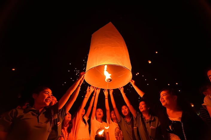 a photo of a group of people launching a floating Chinese lantern