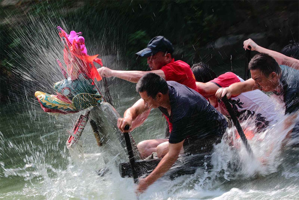 photo of men rowing a dragon boat during Dragon Boat Festival, a popular Chinese holiday