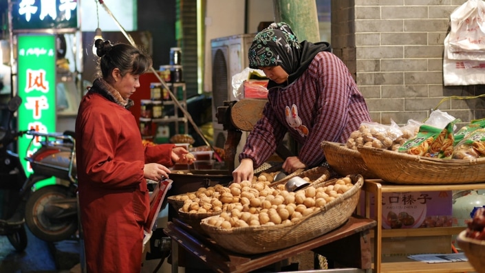 a Chinese Muslim woman selling walnuts