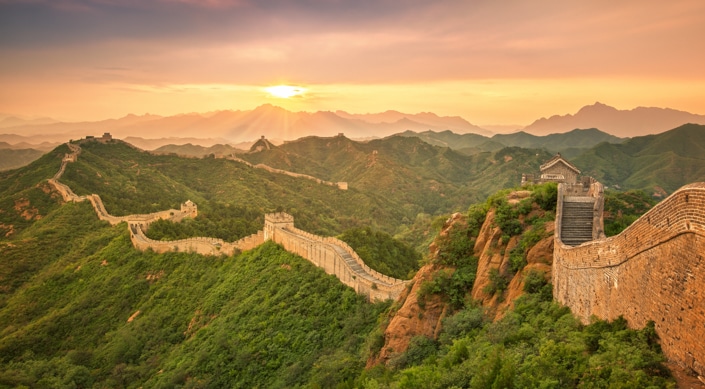 the sun rising over the Great Wall