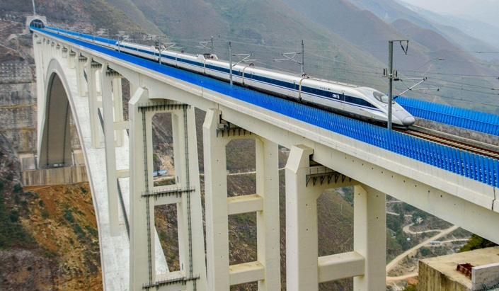 a Chinese fast train crossing a bridge over a ravine
