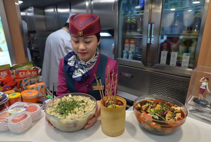 a Chinese female train attendant prepares food for passengers in a dining car