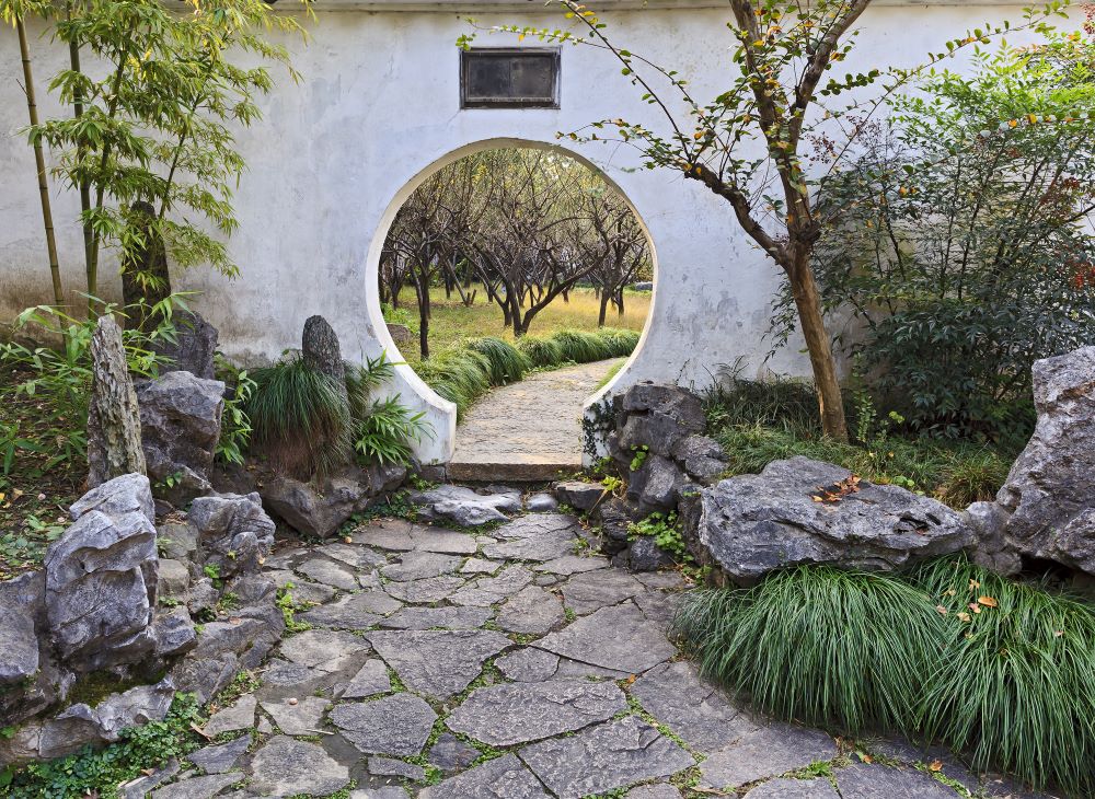 a round door in a wall in a traditional Chinese garden