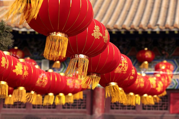 red Chinese lanterns with yellow tassels hanging in a row