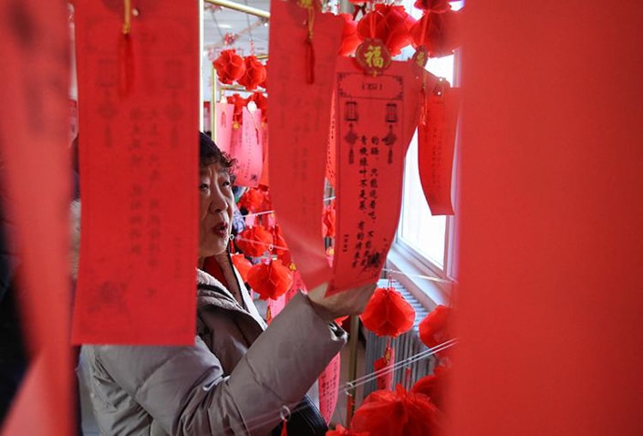 a woman looking at red Lantern Festival riddles