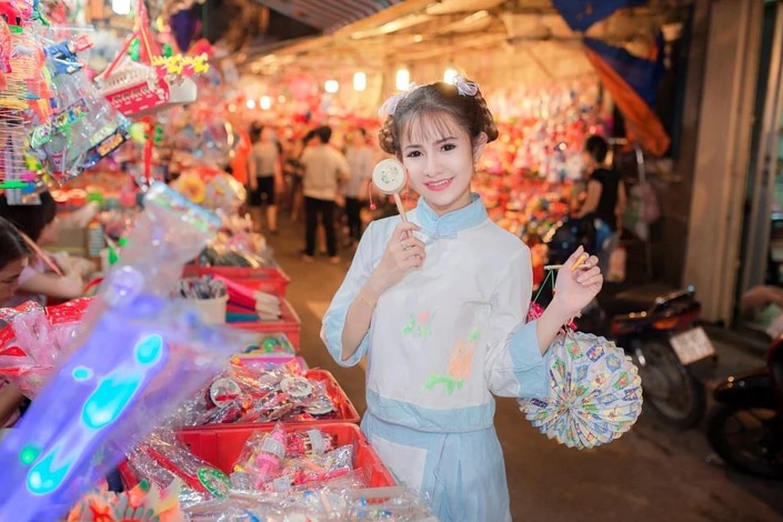 a Chinese girl buying souvenirs at an outdoor market