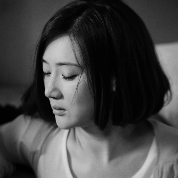 a black and white photo of a Chinese woman looking sad after experiencing pressure to conform with beauty standards in China
