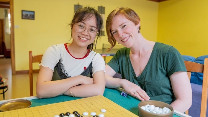 a CLI teacher and student posing with a game of Go