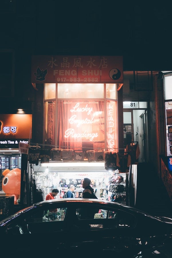 a night view of an illuminated store front advertising fortune telling and feng shui
