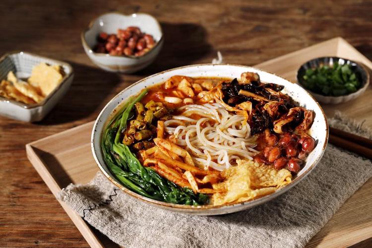 a bowl of Chinese luosifen noodles with lots of toppings. 