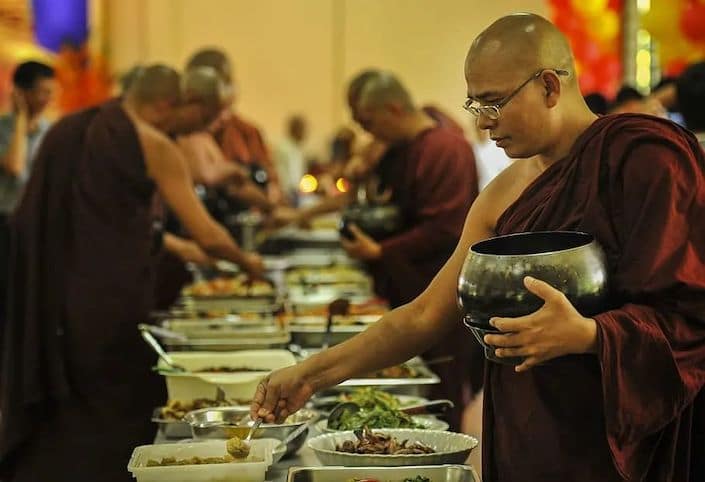 buddhist man getting food at a vegetarian buffet