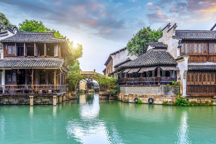 blue-green water in front of old wooden chinese structures in wuzhen water town